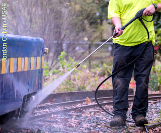 Ammattilainen puhdistaa kalustoa painepesurilla